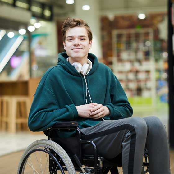 A young man in a wheelchair smiling